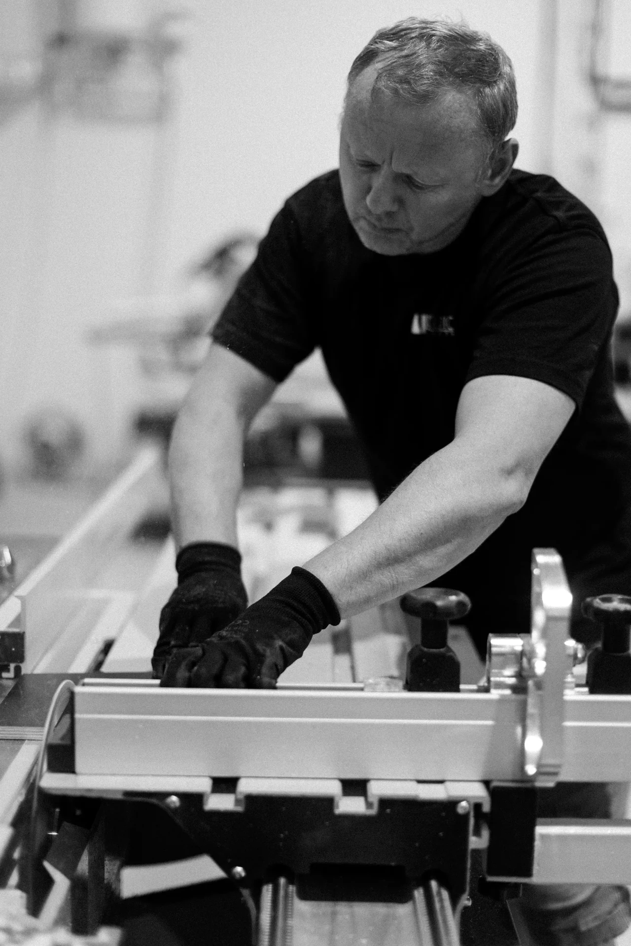 Technician guiding a stone panel through a precision saw table
