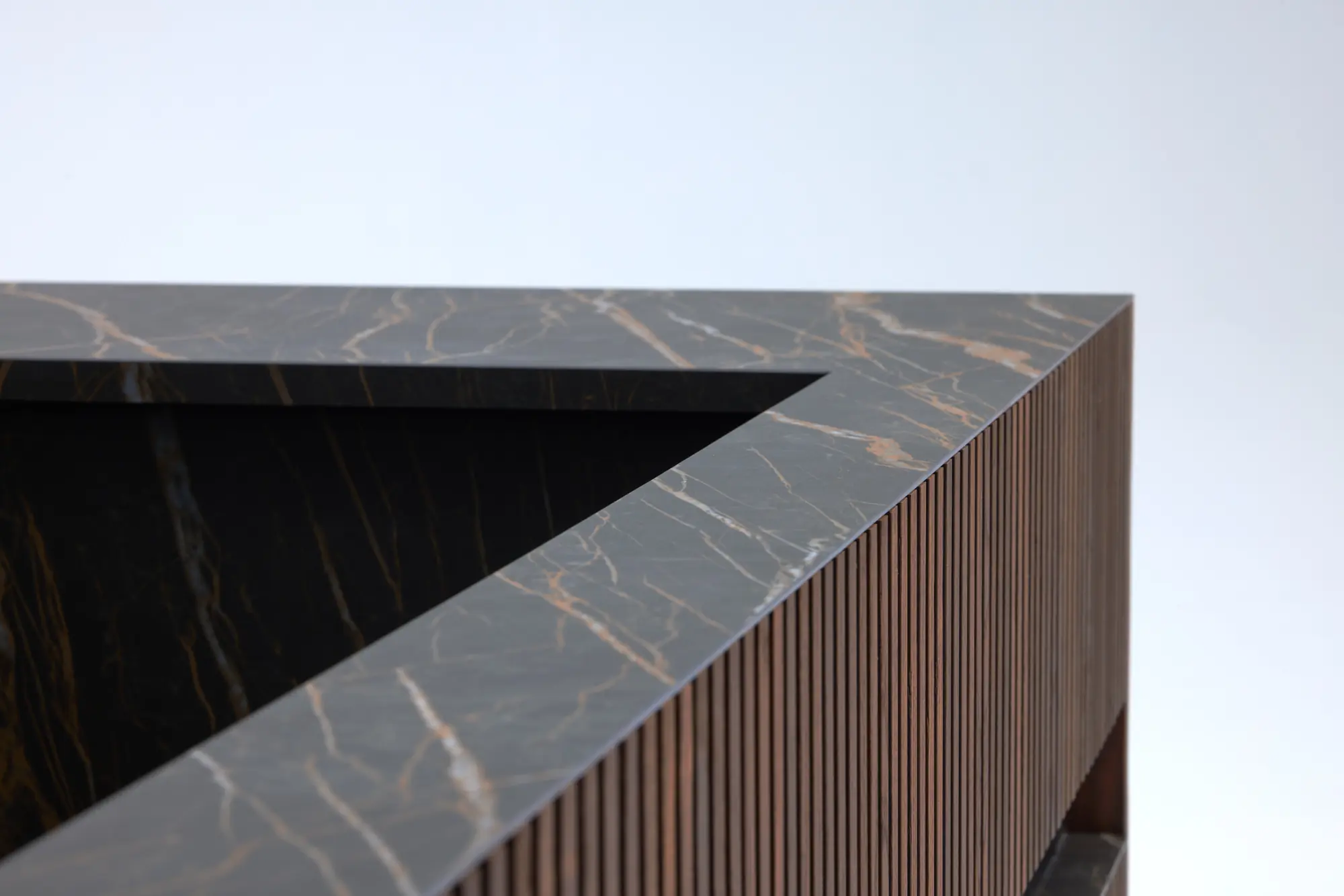 Precision stone joint meeting fluted timber on a finished wellness cabinet